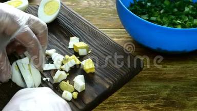 用青葱做春鸡蛋沙拉。 <strong>一步一步</strong>。 煮熟的鸡蛋在木制厨房板上切碎。